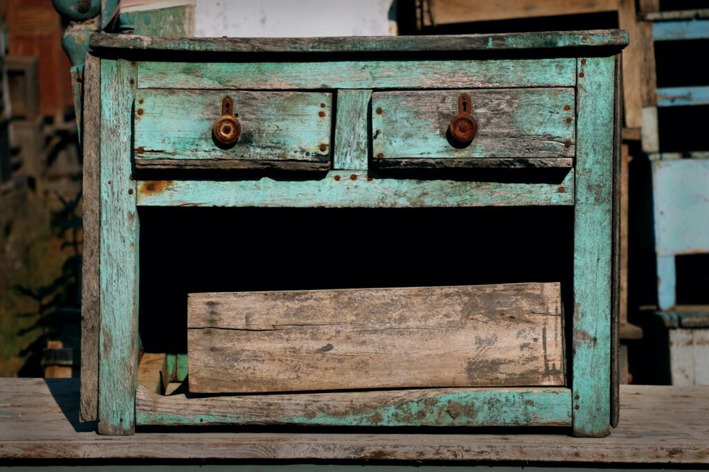 Close-up of distressed painted dresser edge revealing dark wood underneath