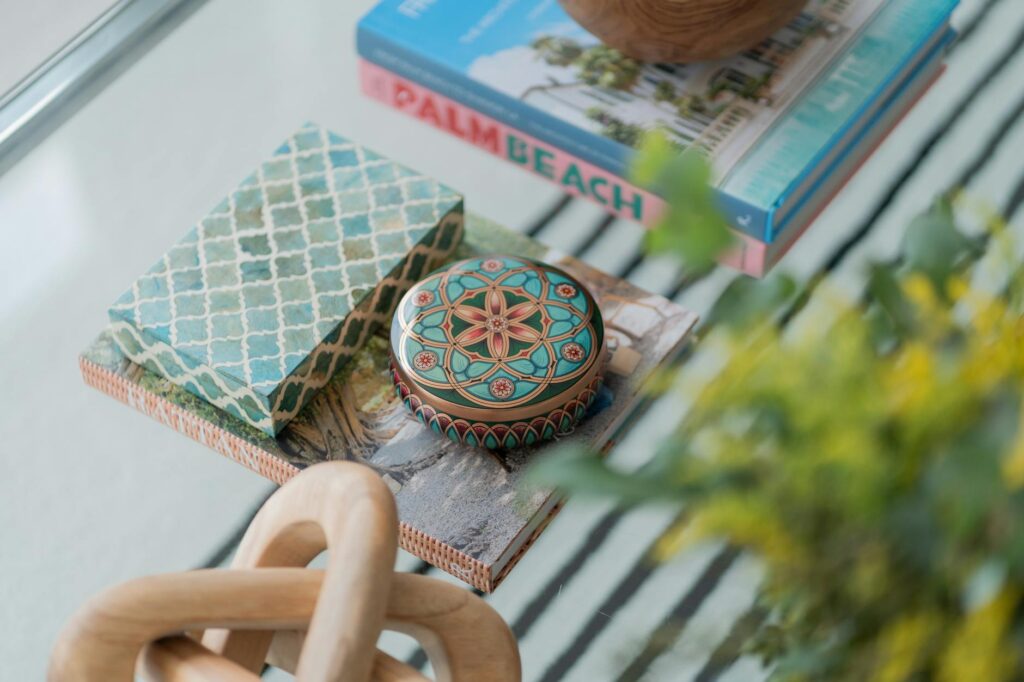 Styled coffee table with a tray, stacked books, candle, and a small plant