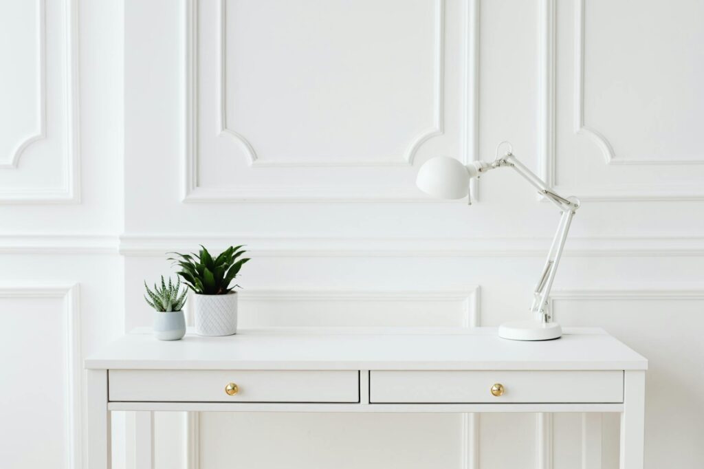Antique brass cup pulls installed on a white painted dresser drawer